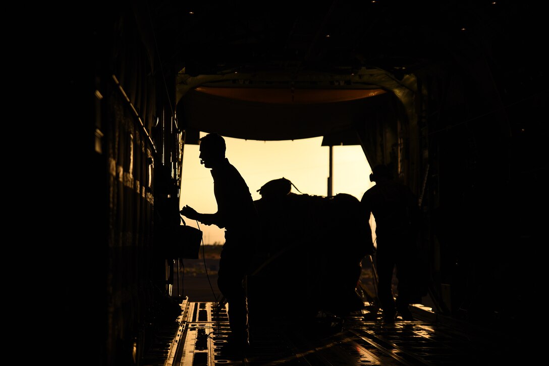 Airmen load cargo into an aircraft.