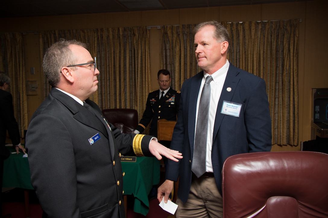 Rear Adm. Shepard Smith, with the National Oceanic and Atmospheric Administration and Mississippi River Commission member, speaks with Peter Nimrod, with the Mississippi Levee Board, during the public hearing in Rosedale, Mississippi, April 10, 2019.