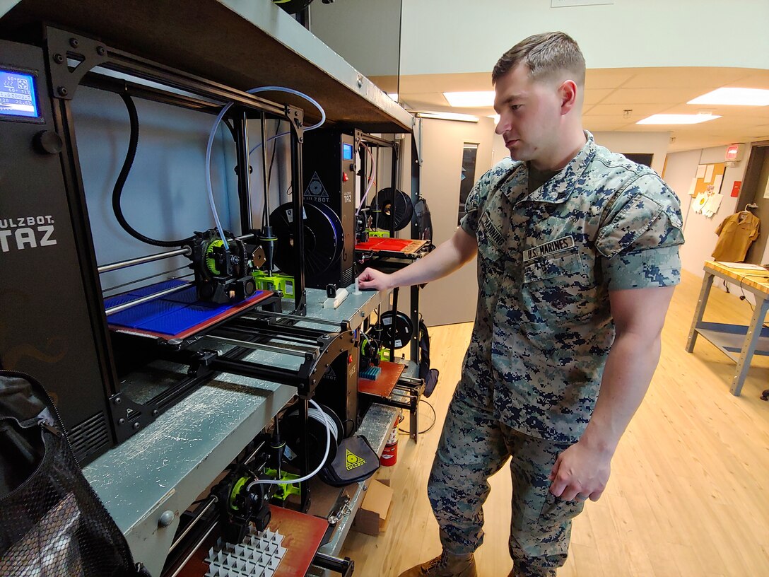 U.S. Marine Corps Cpl. Steven Manning, with Combat Logisitcs Battalion 8, 2nd Marine Logistics Group, watches parts being printed at the Makerspace on Camp Lejeune, North Carolina April 16, 2019. The Makerspace is a collaborative environment for Marines and Sailors to cultivate an innovative culture to explore new ideas to improve policeis, procedures, or products in order to increase readiness.  (U.S. Marine Corps photograph by Gunnery Sgt. Jason W. Fudge)
