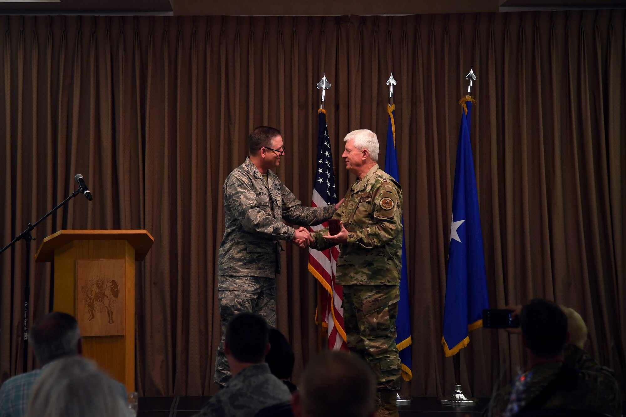 Ch. (Brig. Gen.) Ronald Harvell, Air Force Deputy Chief of Chaplains, accepts a memoir from Col. Benjamin Spencer, 319th Air Base Wing commander, during a National Day of Prayer luncheon on Grand Forks Air Force Base, North Dakota. Airmen, family members and community guests attended the luncheon, at which Harvell spoke about how to pray for the military. (U.S. Air Force photo by Senior Airman Elora J. Martinez)