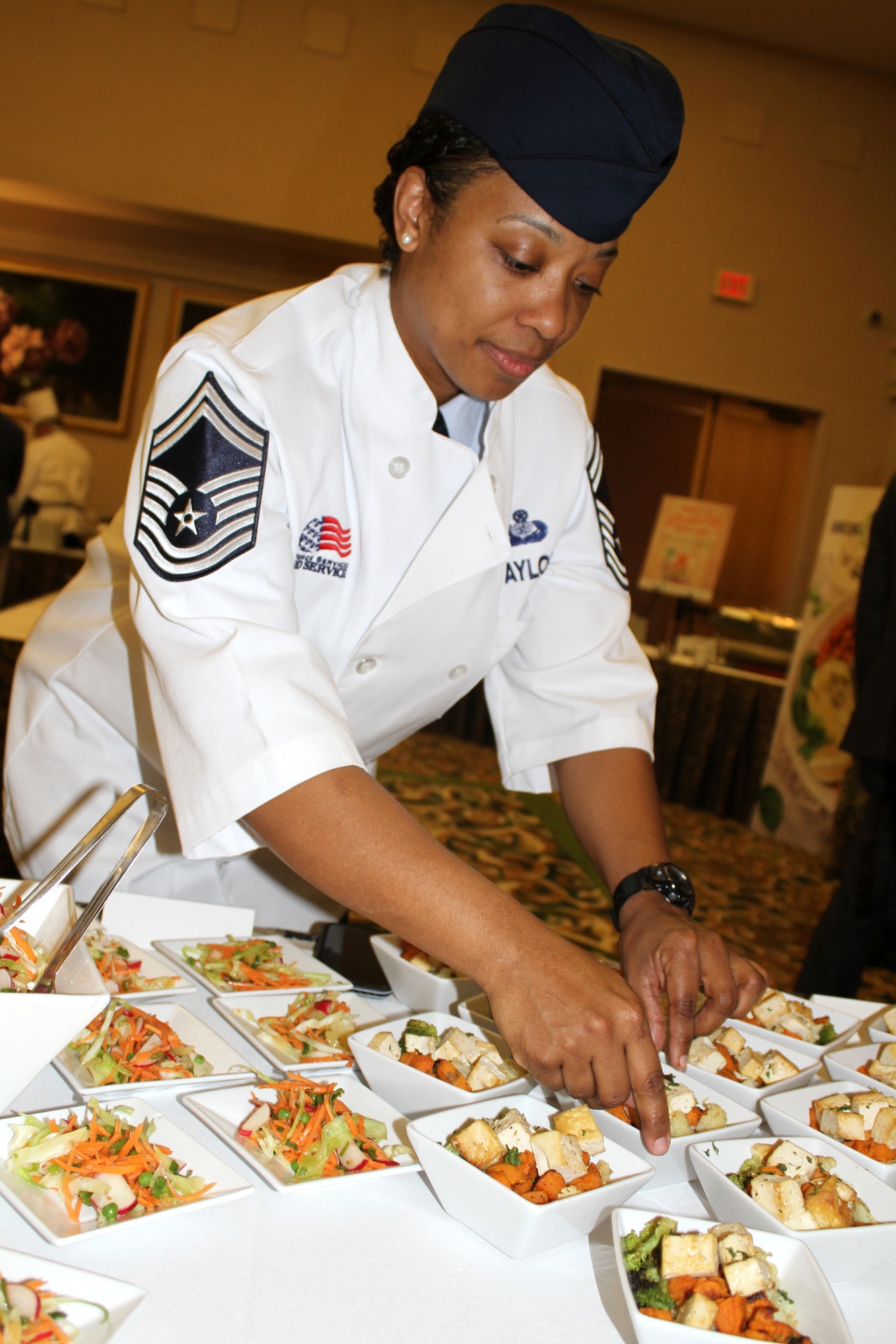 Senior Master Sgt. Tashon Taylor, AFSVA Food and Beverage superintendent, positions grain bowls with grilled tofu for a Healthy Food Initiative lunch during the General Officer and Senior Executive Service Summit April 10, 2019, at Joint Base San Antonio-Lackland. AFSVA prepared various healthy and nutritious food items to familiarize summit attendees with Healthy Food Initiative, a dining concept being rolled out across the Air Force that’s designed to deliver fresh, healthy, nutritious and tasty food to Airmen. (U.S. Air Force photo by Debbie Aragon)