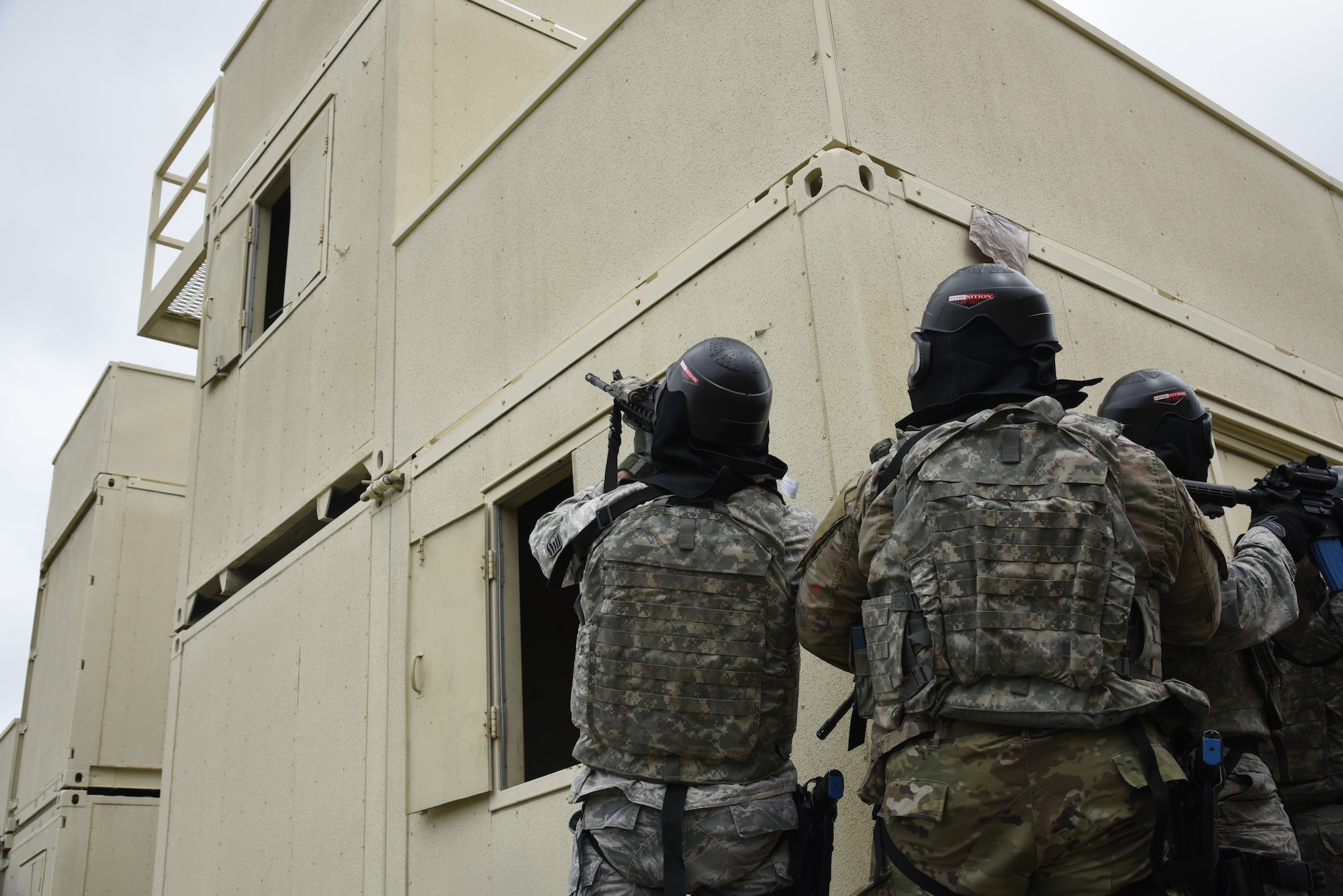 A fire team with the 114th Security Forces Squadron tactically moves through a mock village designed for Military Operations in Urban Terrain (MOUT) training at Marine Corps Base Camp Pendleton, California.