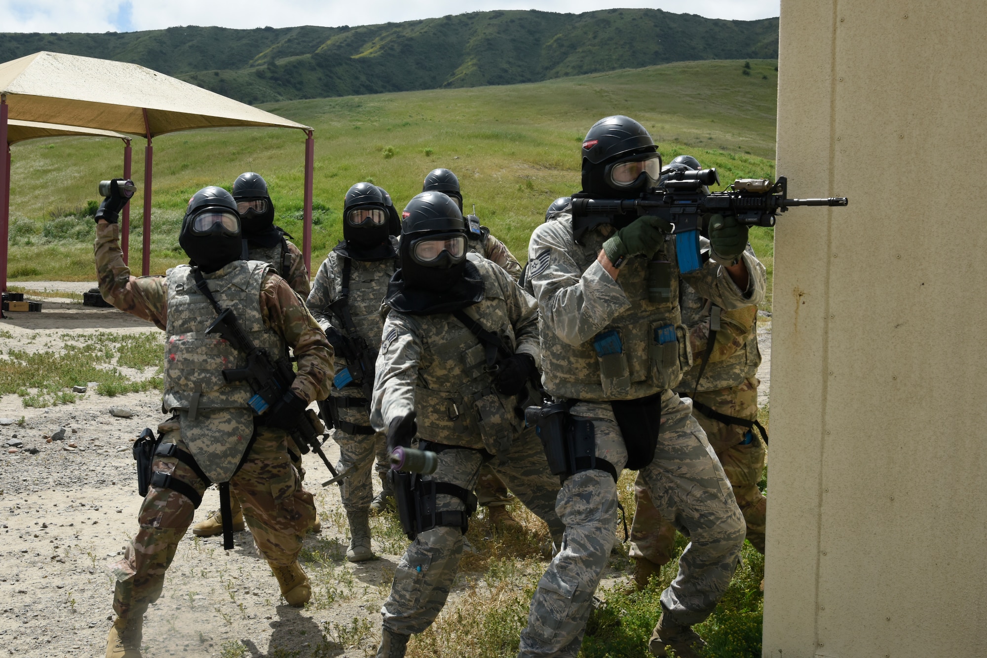 Members of the 114th Security Forces Squadron throw smoke grenades prior to entering a village during their military operations in urban terrain (MOUT) training at Marine Corps Base Camp Pendleton, California.