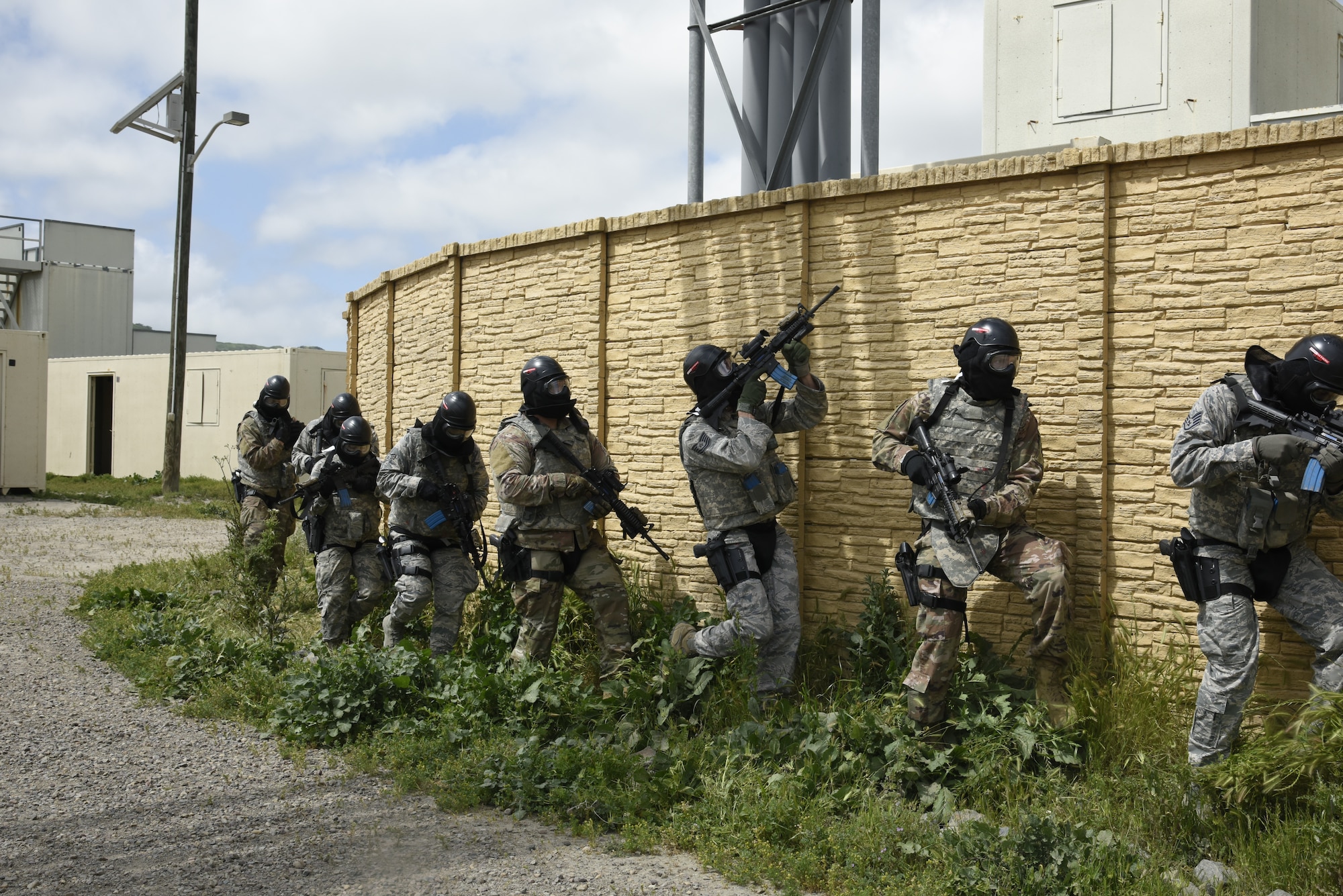 A squad from the 114th Security Forces Squadron tactically moves through a mock village designed for Military Operations in Urban Terrain (MOUT) training at Marine Corps Base Camp Pendleton, California.