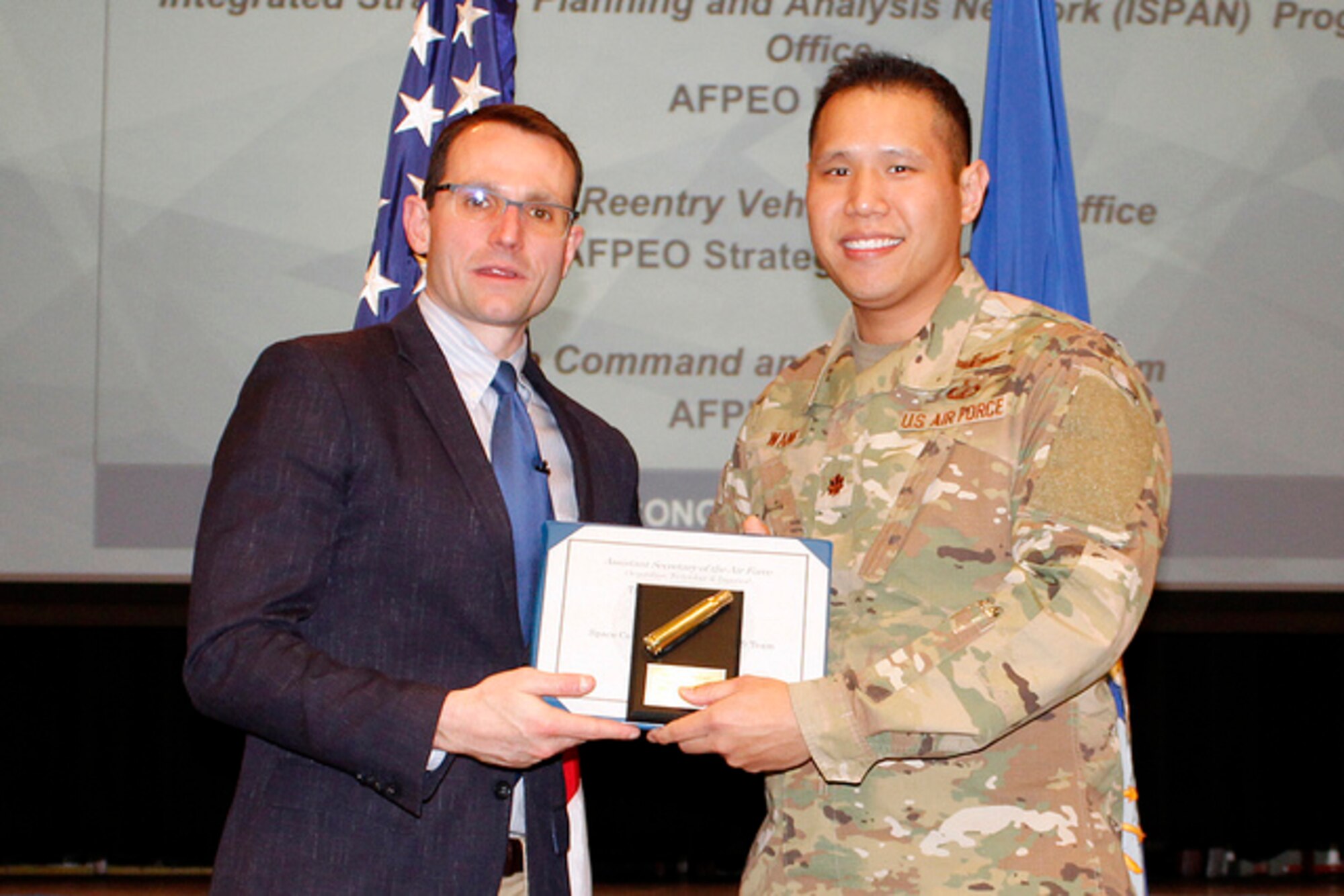 Dr. Will Roper, Assistant Secretary of the Air Force for Acquisition, Technology and Logistics presents Maj. Andy Wang, Program Element Monitor for Space C2, on behalf of the SMC SY team, with the “Tailored 5000” award, March 4, 2019 in Washington D.C. [USAF Courtesy Photo]