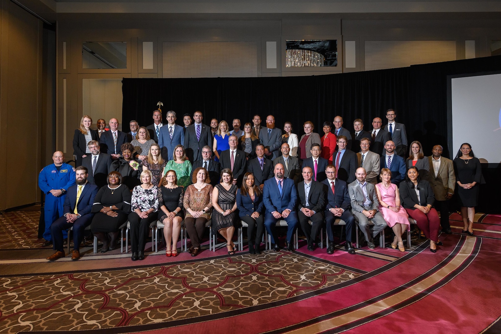 A group of award recipients and presenters stand together for a photo