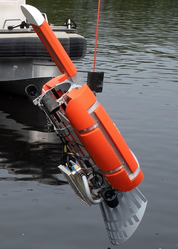 An unmanned underwater vehicle device is lowered into the water.