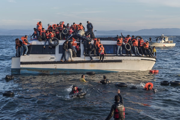 Syrian and Iraqi refugees arrive from Turkey to Skala Sykamias, Lesbos island, Greece, while volunteers (life rescue team, with yellow-red clothes) from the Spanish nongovernmental organization Proactiva Open Arms offer help.