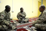 In this 2013 photo, Sgt. Marcus Lewis talks with Pvt. Munir Muhammed both with Task Force Dragoon and Sgt. Richard Blevins with the 115th Military Police Detachment at the Kandahar Islam Center during Ramadan. This was the first time Lewis and Muhammed attended services at the center.  The Soldiers were deployed in support of Operation Enduring Freedom.