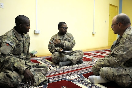 In this 2013 photo, Sgt. Marcus Lewis talks with Pvt. Munir Muhammed both with Task Force Dragoon and Sgt. Richard Blevins with the 115th Military Police Detachment at the Kandahar Islam Center during Ramadan. This was the first time Lewis and Muhammed attended services at the center.  The Soldiers were deployed in support of Operation Enduring Freedom.