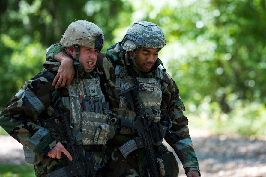 An Airman assists wounded personnel to a Humvee after responding to a simulated ground attack during exercise