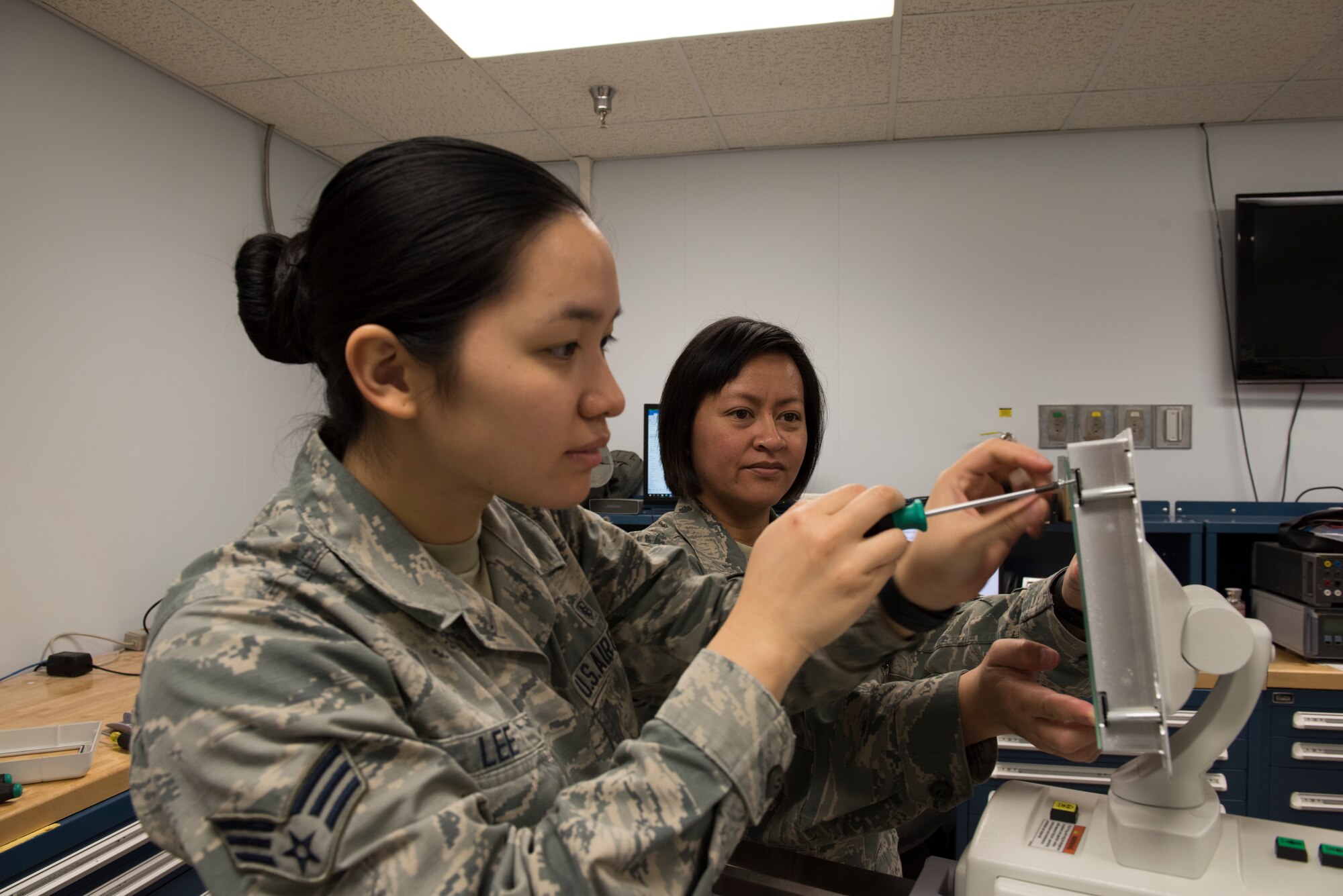 Tech. Sgt. Kristine Richardson, 39th Medical Support Squadron biomedical equipment NCO in charge, right, and Senior Airman Kirsten Lee, 39th MDSS biomedical equipment technician, left, install a screen on an X-ray machine March 29, 2019, at Incirlik Air Base, Turkey.