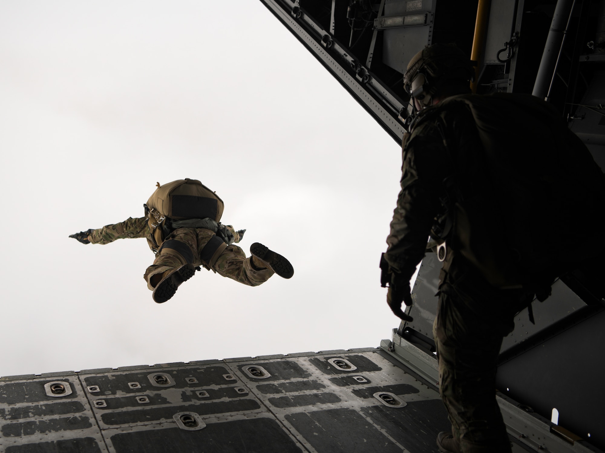 A special tactics operator jumps out of the back of an MC-130H