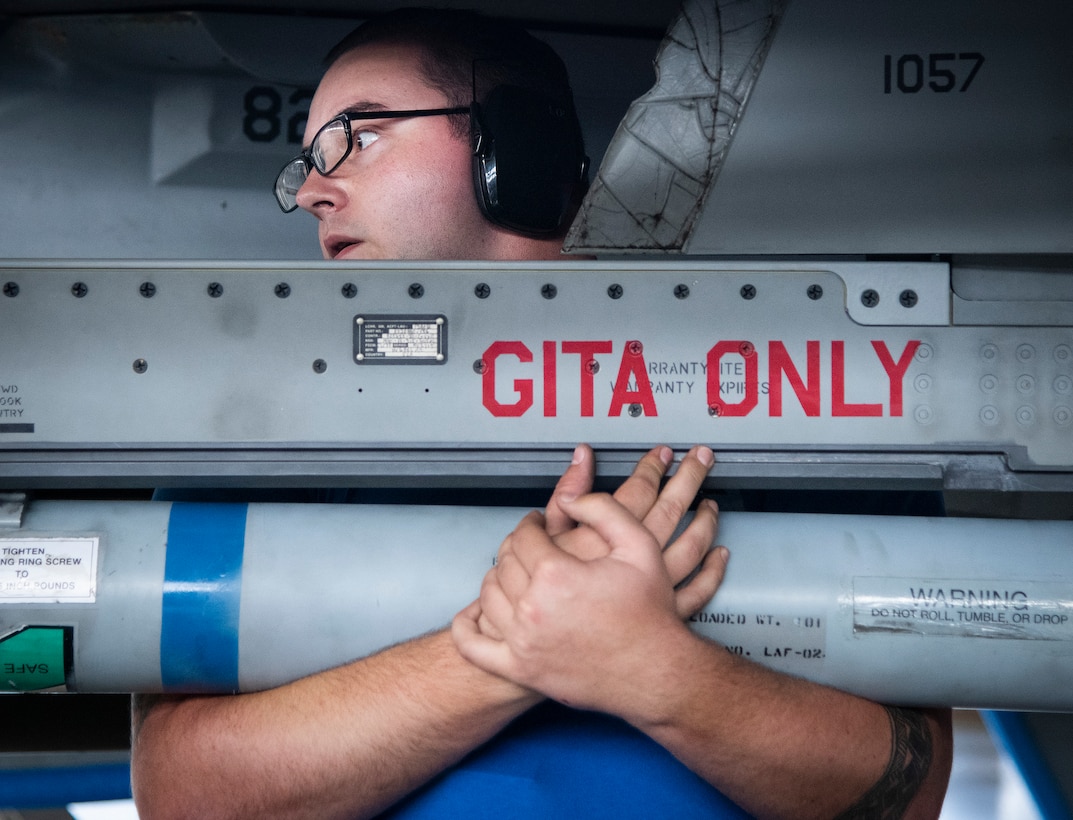 An Airman holds an AIM-9X missile