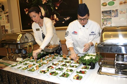 Christie Maas and Tech. Sgt. Audrey Easterling, food and beverage managers at the Air Force Services Activity, put the finishing touches on pumpkin curry and Mediterranean bowls for a Healthy Food Initiative lunch during the General Officer and Senior Executive Service Summit April 10, 2019, at Joint Base San Antonio-Lackland. AFSVA prepared various healthy and nutritious food items to familiarize summit attendees with HFI, a dining concept being rolled out across the Air Force.