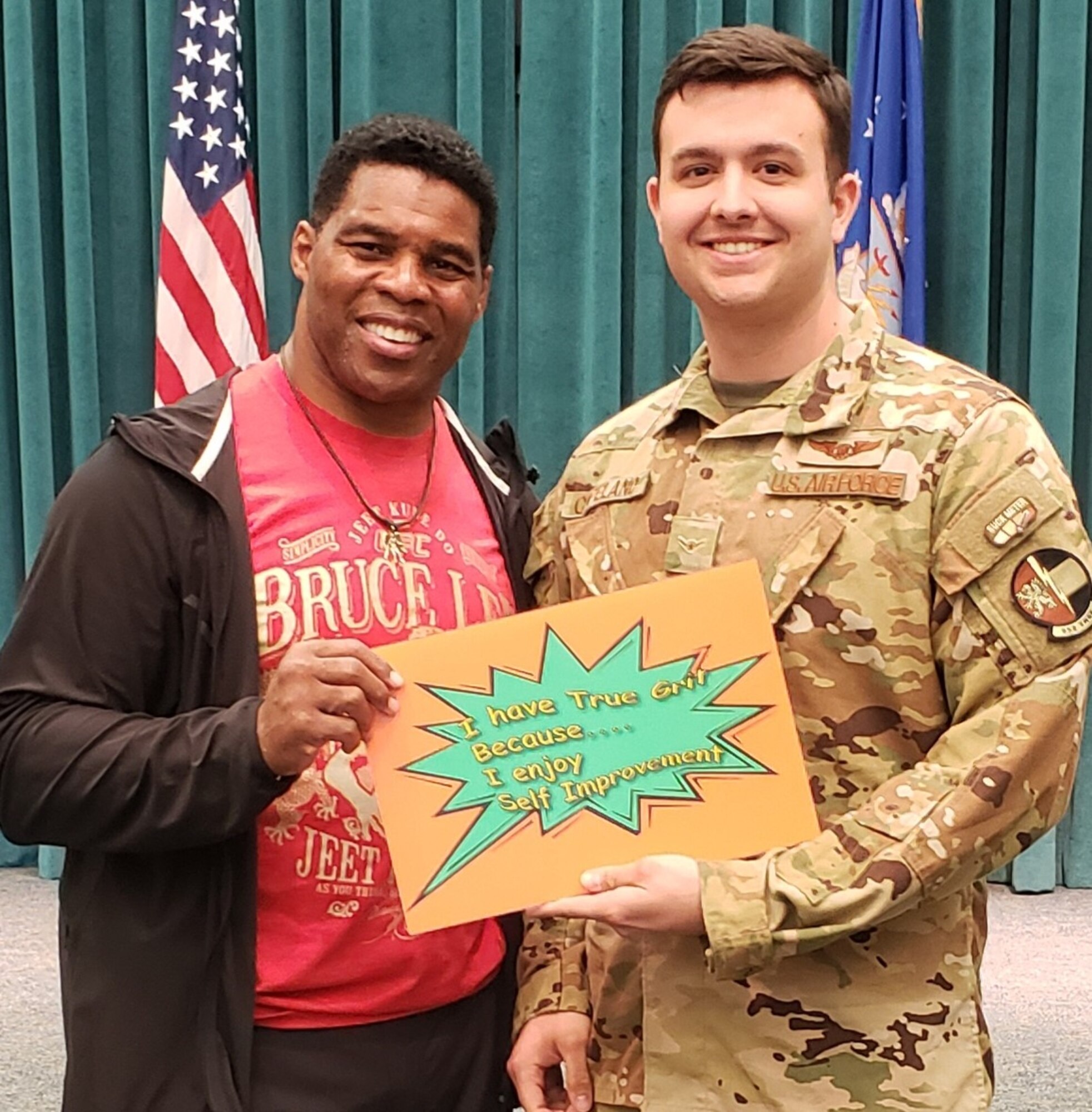 Former NFL Star and Heisman Trophy winner Herschel Walker kicked off the True Grit campaign when he visited Tinker on March 25 to talk to the Oklahoma City Air Logistics Complex, 552nd Air Control Wing and the 72nd Air Base Wing about the grit that it took to overcome his personal obstacles. Walker is pictured with Airman 1st Class Gregory Copeland of the 963rd Airborne Air Control Squadron with a painting of how true grit is exemplified to him, self improvement. (Courtesy photo)
