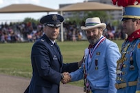 Col. Jason Janaros, 37th Training Wing commander, presents a Fiesta medal to 2019 Fiesta Royalty, San Antonio Fiesta Commission president Byron LeFlore, Jr. a gift during the Air Force Basic Military Training Fiesta graduation Parade April 19, 2019, at Joint Base San Antonio-Lackland,