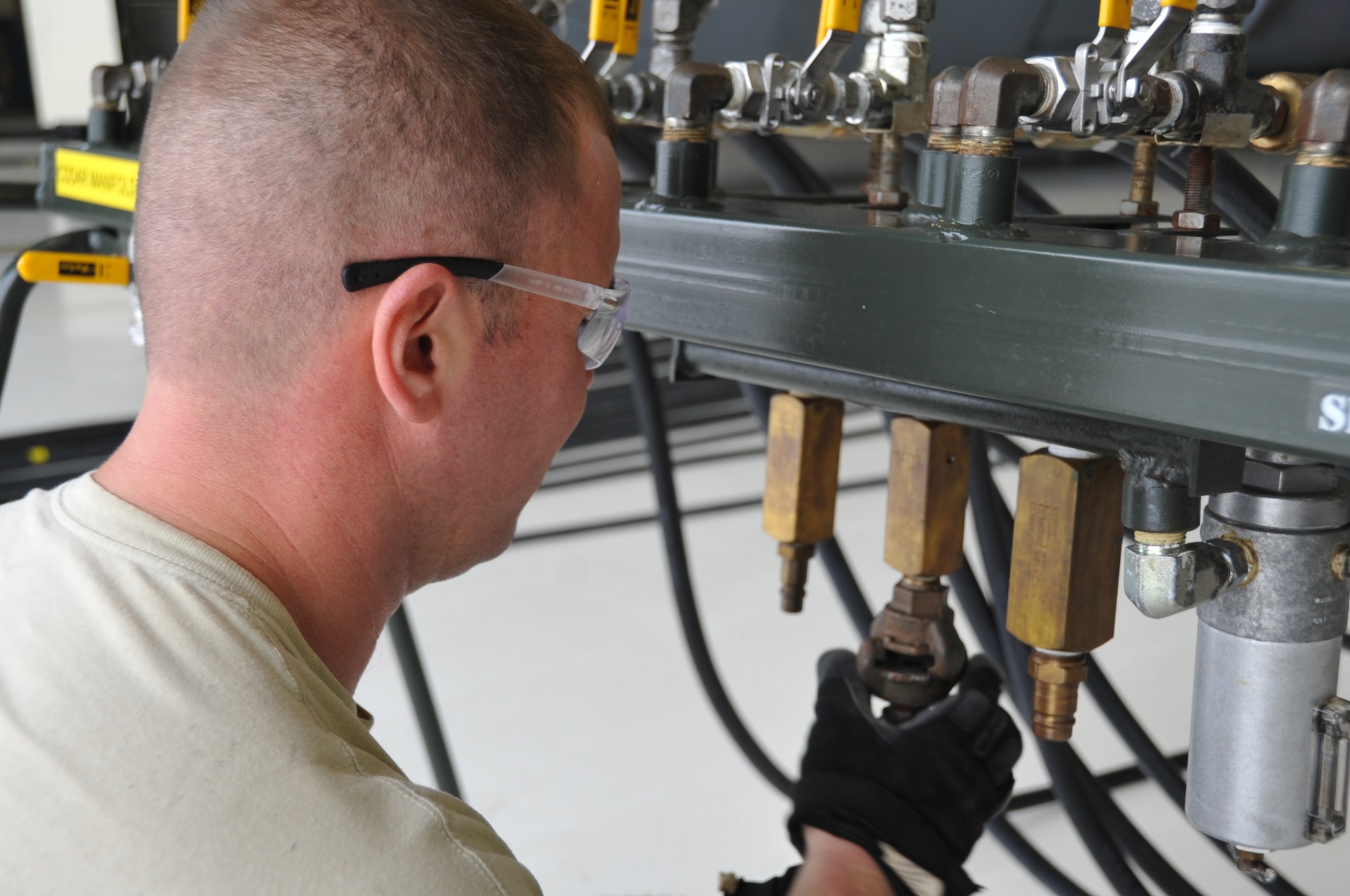 Master Sgt. Rickey Carroll, 403rd Aircraft Maintenance Squadron hydraulics craftsman, attaches the hose from the MC7/air compressor to the control consol manifold stand. Members of the 403rd Wing Crash, Damaged or Disabled Aircraft Recovery team work together during a training exercise held during the March Unit Training Assembly at Keesler Air Force Base. The CDDAR training is an annual requirement to maintain proficiency and ensure that all equipment is serviceable and operational.  (U.S. Air Force photo by Master Sgt. Jessica Kendziorek)