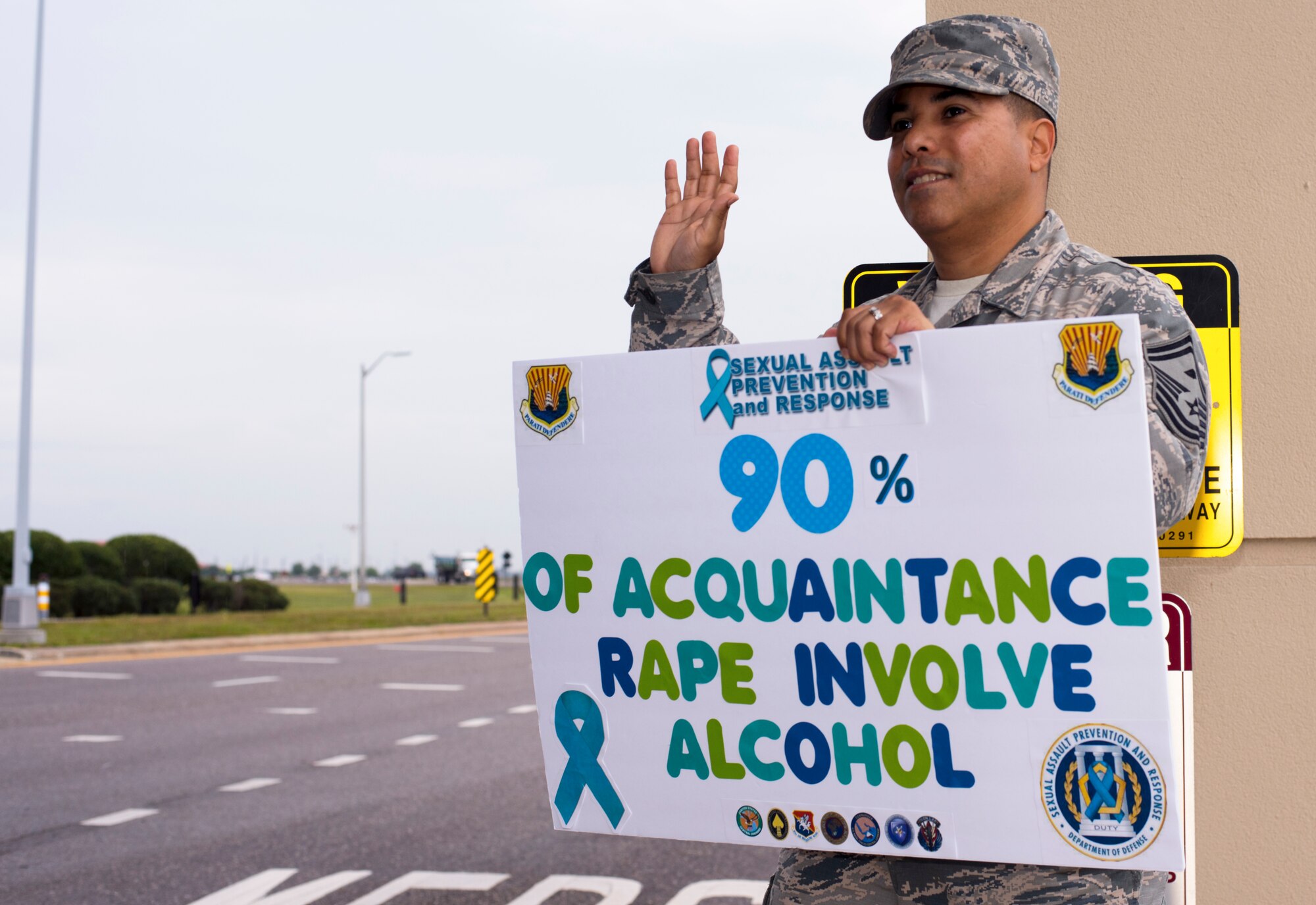 U.S. Air Force Senior Master Sgt. Jason Olivencia, the 6th Medical Group first sergeant, stands at Dale Mabry Gate with a Sexual Assault Prevention and Response awareness sign at MacDill Air Force Base, Fla., April 2, 2019.