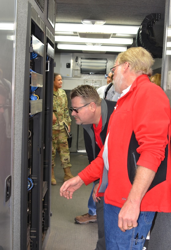 Mark McKay (center) and Howard Bulick (right), both from the Portland District, examine some of the equipment in an ECCV during the exercise, April 17, 2019.
