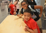 Two girls and a boy stand next to a teambuilding project they made.