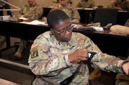 Master Sgt. Alisha Hunt-Harris, a financial management inspector with the 18th Financial Support Center, 1st Theater Sustainment Command, applies a tourniquet to her arm April 24, 2019 during the Blackjack Life Saver Course at Fort Knox. Ky.
