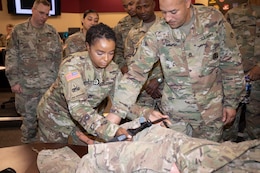 Master Sgt. Shavonda Devearaux, Surgeon Cell noncommissioned officer in charge, 1st Theater Sustainment Command, demonstrates the proper way to apply a tourniquet April 24, 2019 during the Blackjack Life Saver Course at Fort Knox, Ky.