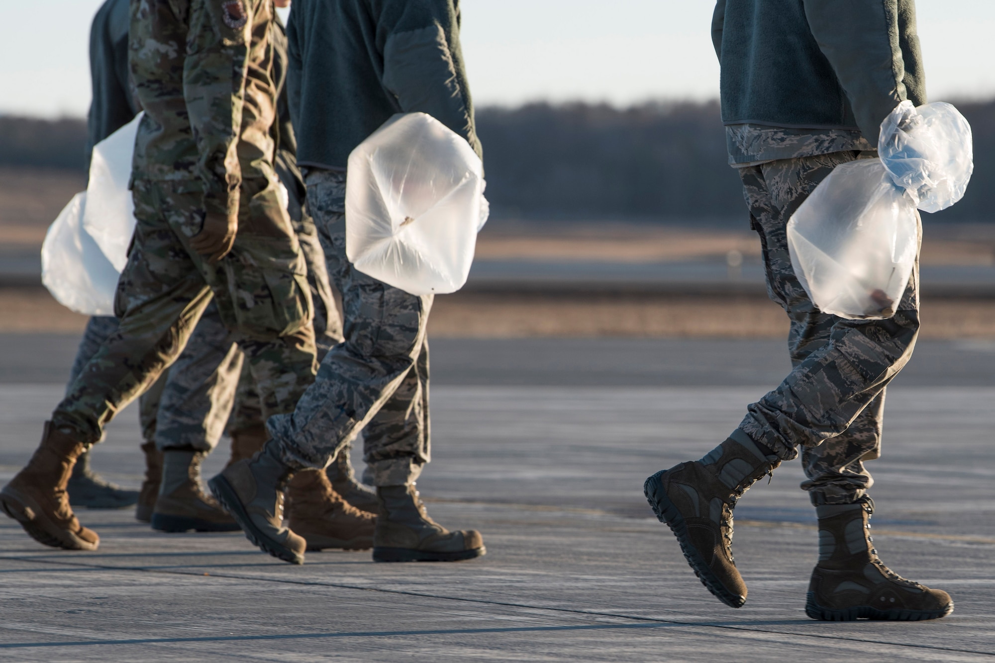 U.S. Airman from the 3rd Wing, 176th Wing, and 477th Fighter Group conduct a foreign object debris walk on the flightline at Joint Base Elmendorf-Richardson, Alaska, April 26, 2019. Airmen conducted the FOD walk to remove debris that could damage aircraft and hinder mission readiness.