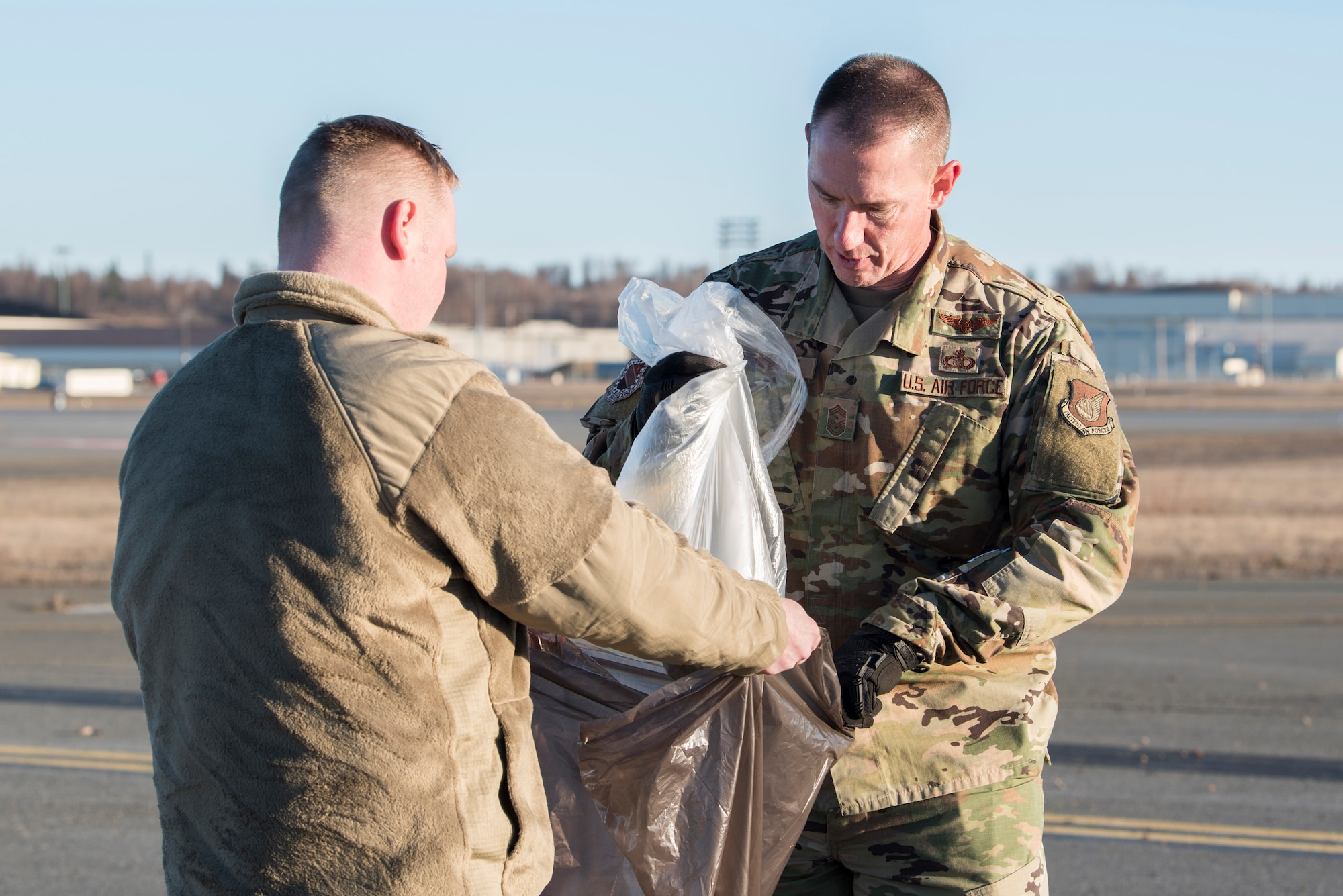 U.S. Airman from the 3rd Wing, 176th Wing, and 477th Fighter Group conduct a foreign object debris walk on the flightline at Joint Base Elmendorf-Richardson, Alaska, April 26, 2019. Airmen conducted the FOD walk to remove debris that could damage aircraft and hinder mission readiness.