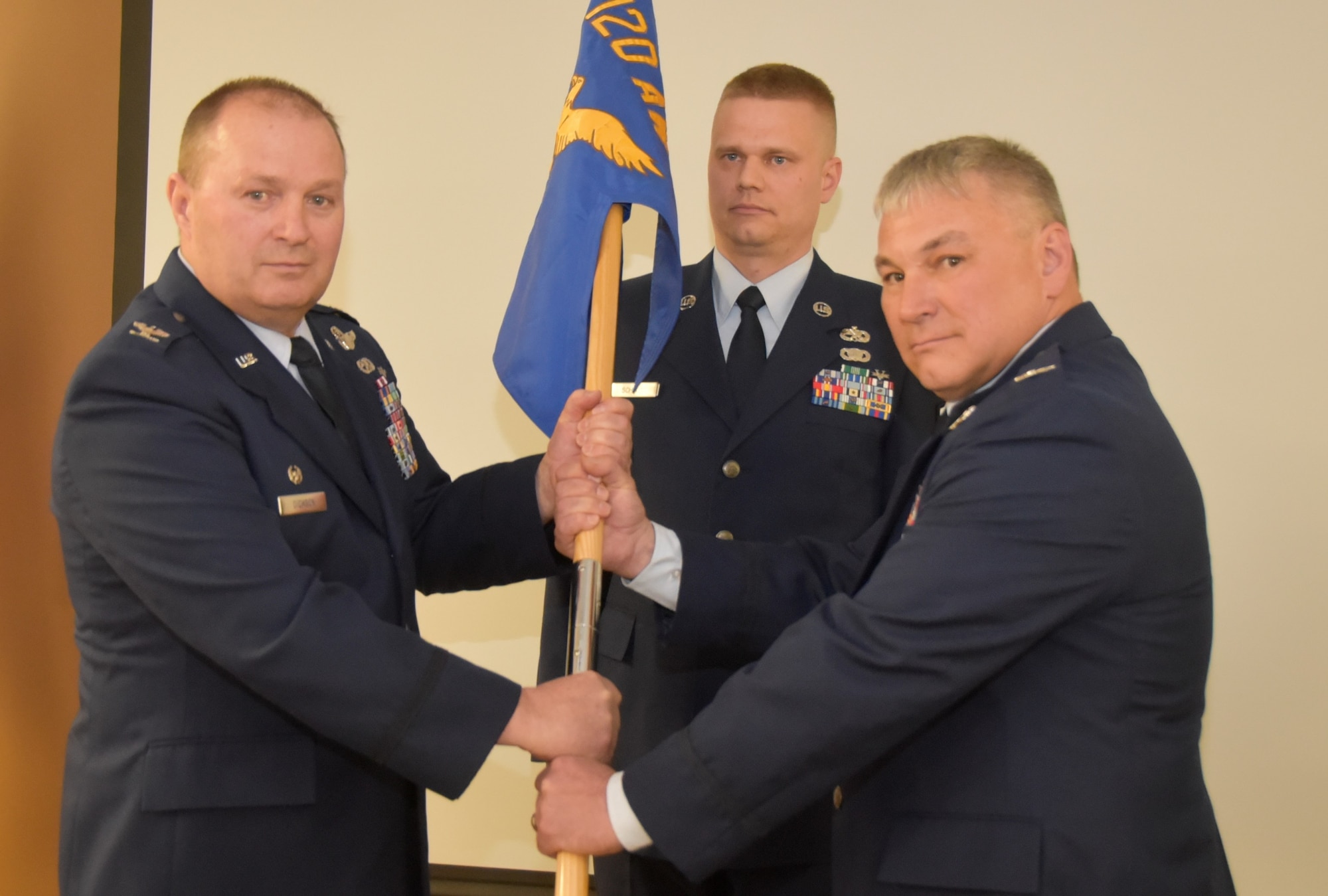 Col. Trace Thomas, right, accepts the 120th Maintenance Group guideon from Col. Buel Dickson, 120th Airlift Wing commander, Montana Air National Guard, during a change of command ceremony April 6, 2019, Great Falls, Montana. The outgoing maintenance commander, Col. Larry Gardner, was selected as the next commander of the 141st Air Refueling Wing, Fairchild Air Force Base, Washington.