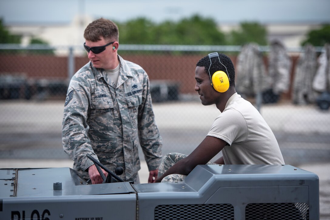 Tech. Sgt. Barry Lewis, left, 363rd Training Squadron munitions apprentice course instructor, coaches student Airman Joshua Pleasant as he drives an MHU-83 bomb lift truck at Sheppard Air Force Base, Texas, April 24, 2019. Pleasant is on block three of his munitions training and this is the first time he is driving the MHU-83. In the first block of training they learn mostly foundational Air Force structure and practices. In the second block they are taught about their career field and from block three and up they start the "real" training, including driving bomb lift trucks and loading training bombs. (U.S. Air Force photo by Airman 1st Class Tenorio)