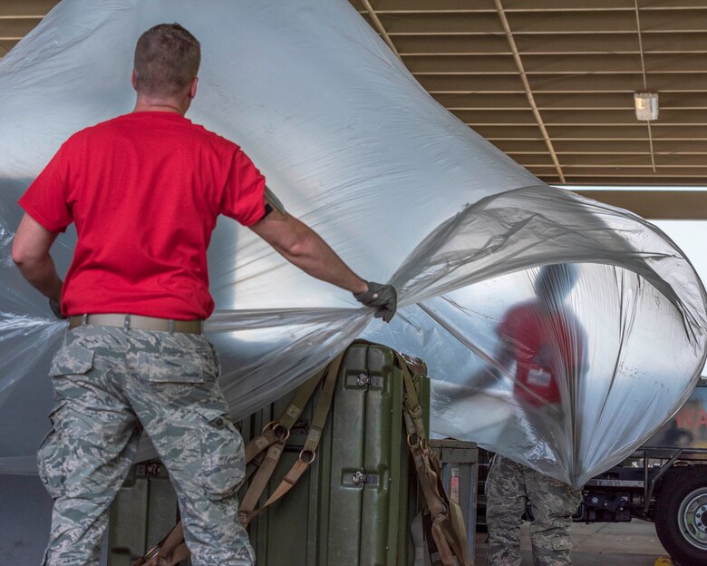 Tech. Sgt. Jeffrey Lawson, Airman First Class Antonio Yancy, 96th Aerial Port Squadron air transportation specialists, cover a pallet of cargo as part of the 2019 Port Dawg Competition, April 23, 2019 at Dobbins Air Reserve Base, Georgia.