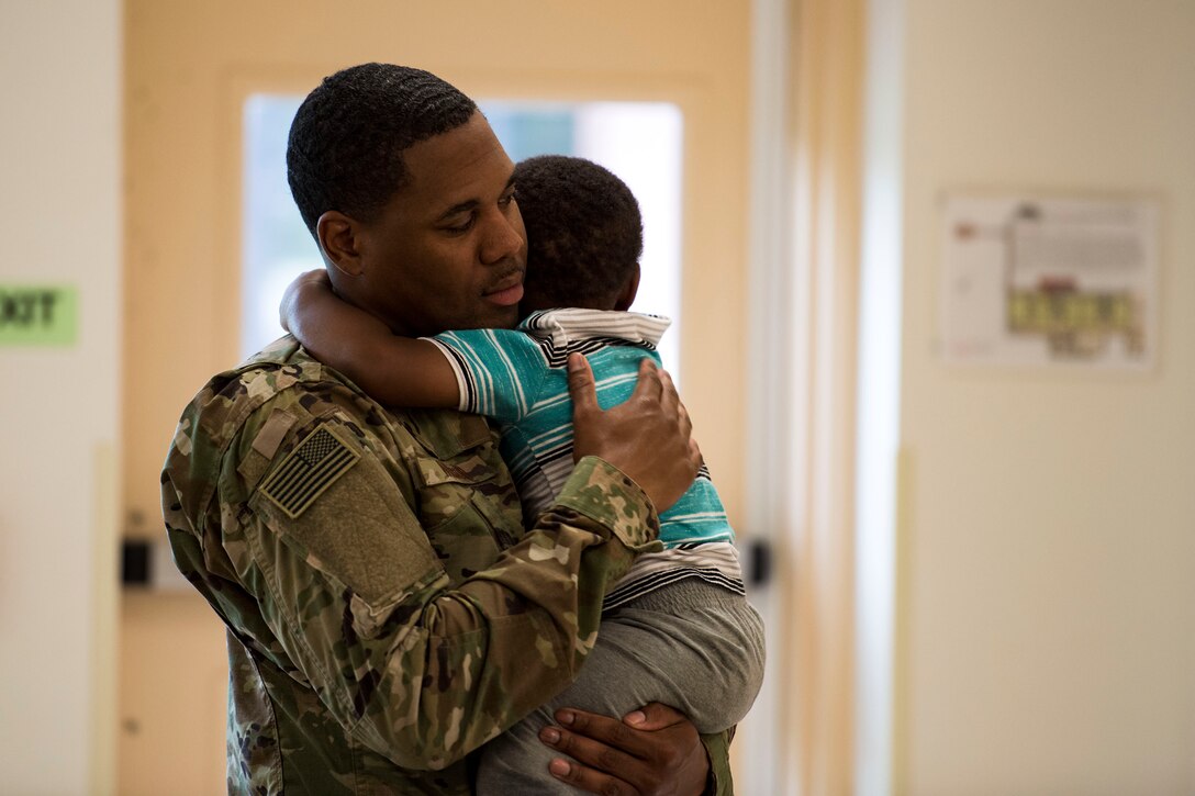 Staff Sgt. Edward Wilson, 6th Security Forces Squadron standardization and evaluation craftsman, hugs his child during the Teddy Bear Picnic, April 26, 2019, at Moody Air Force Base, Ga. The Child Development Center hosted the event in support of the Month of the Military Child in April. (U.S. Air Force photo by Senior Airman Erick Requadt)