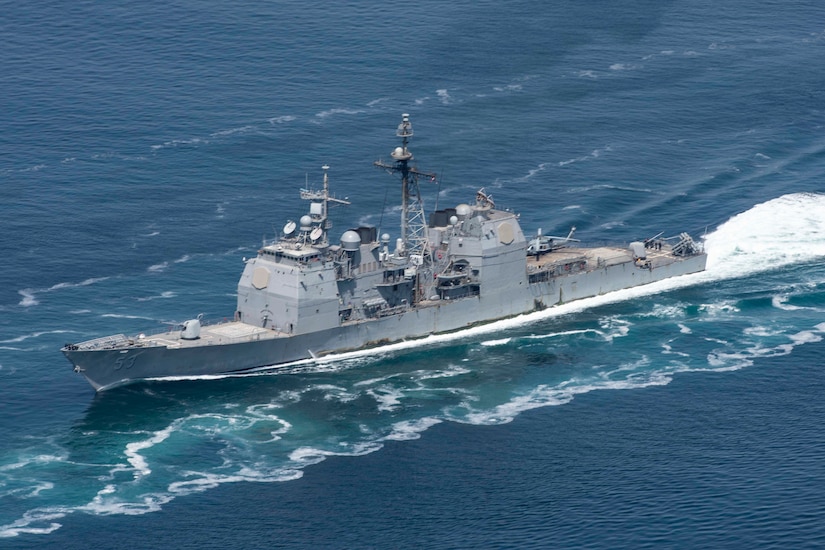 A military ship moves through the ocean.