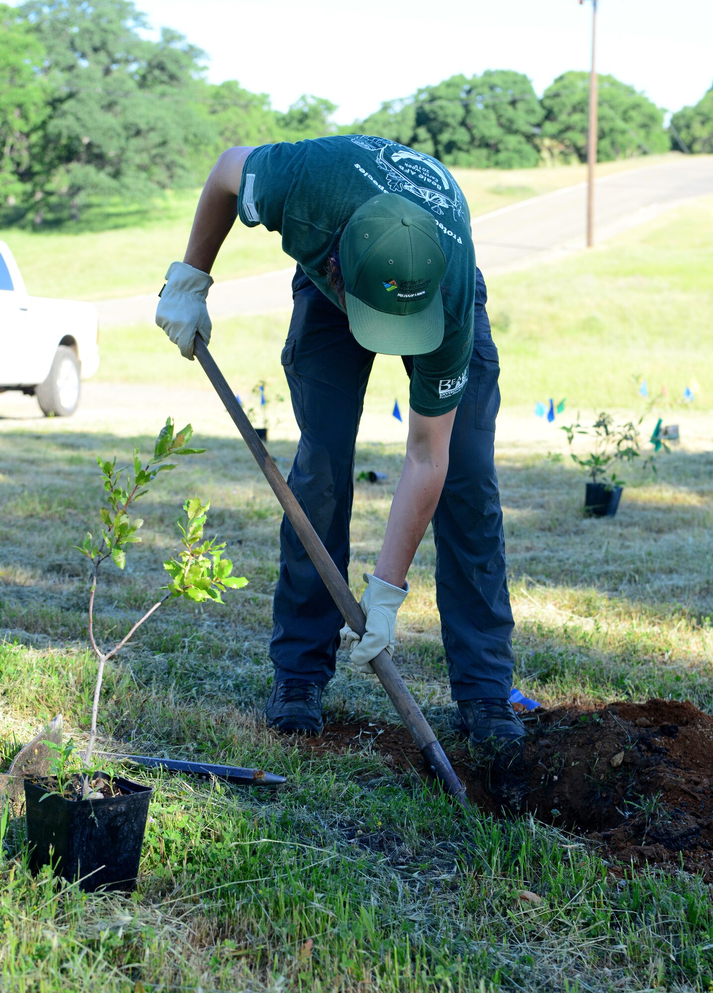 9th Civil Engineer Squadron wildlife biologist, digs a hole during a native tree and shrub planting event during Earth Week 2019