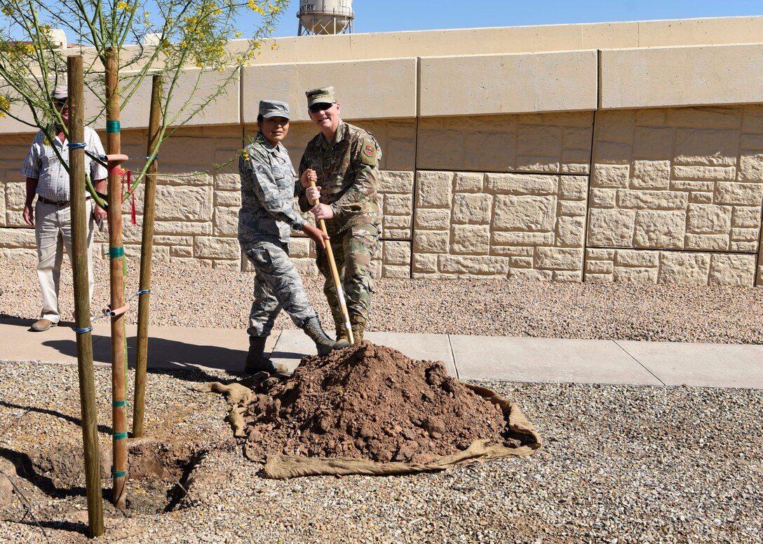 Col. Robert Sylvester, 56th Mission Support Group commander, and Airman 1st Class Lendrena Dez, 56th MSG executive, pose for a photo during an Arbor Day celebration April 26, 2019, at Luke Air Force Base, Ariz. Trees filter the air and water, provide food for humans and wildlife, supply building materials and help prevent soil erosion and flooding. (U.S. Air Force photo by Airman 1st Class Zoie Cox)