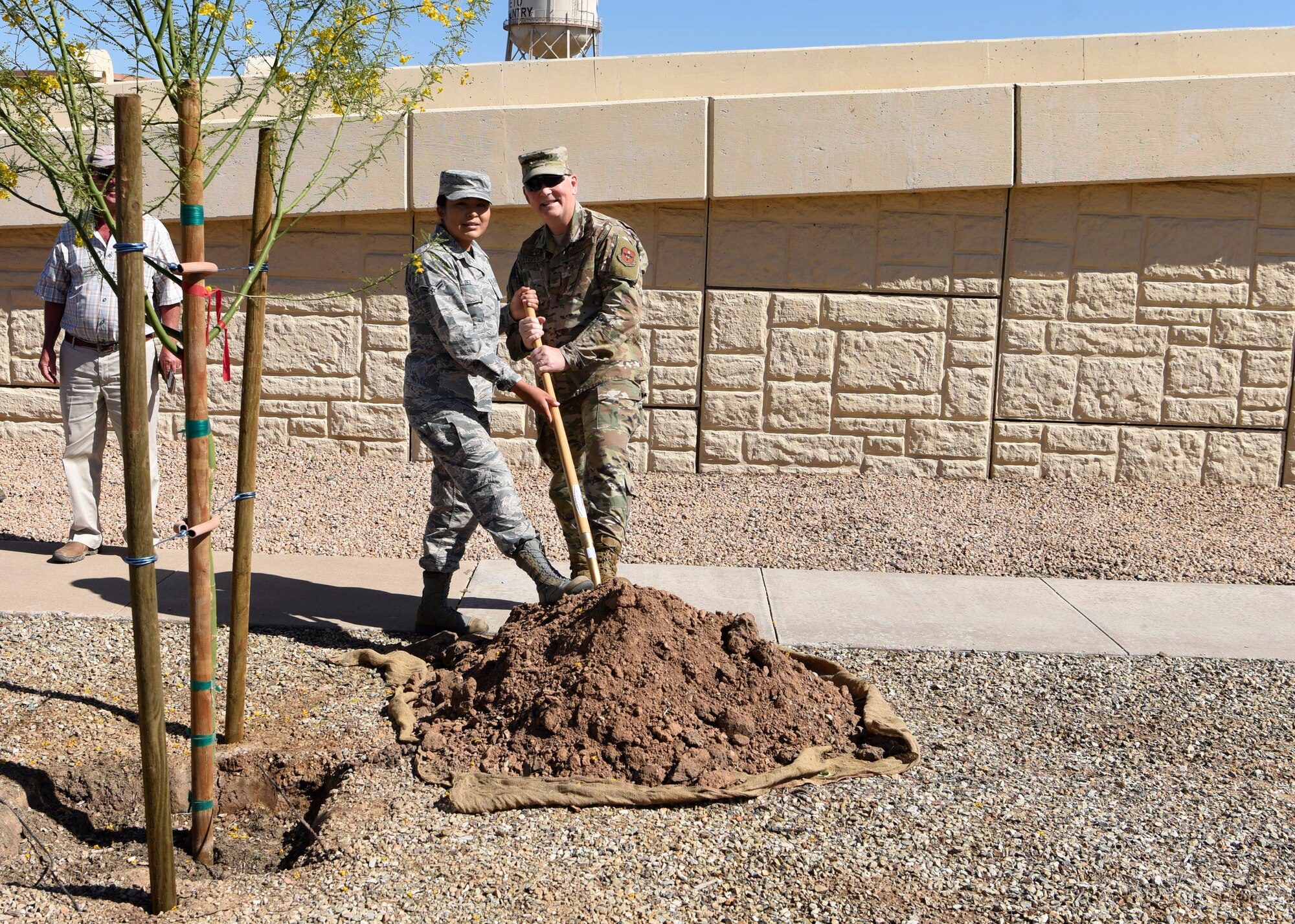 Col. Robert Sylvester, 56th Mission Support Group commander, and Airman 1st Class Lendrena Dez, 56th MSG executive, pose for a photo during an Arbor Day celebration April 26, 2019, at Luke Air Force Base, Ariz. Trees filter the air and water, provide food for humans and wildlife, supply building materials and help prevent soil erosion and flooding. (U.S. Air Force photo by Airman 1st Class Zoie Cox)