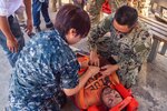 DILI, Timor-Leste (April 26, 2019) – U.S. Navy Lt. Cmdr. Phonthip Eadens and Hospital Corpsman 2nd Class Roberto Songco secure a Timorese man, roleplaying as a victim, to a stretcher during a mass casualty exercise at Guido Valdares National Hospital as part of Pacific Partnership 2019. Pacific Partnership, now in its 14th iteration, is the largest annual multinational humanitarian assistance and disaster relief preparedness mission conducted in the Indo-Pacific.