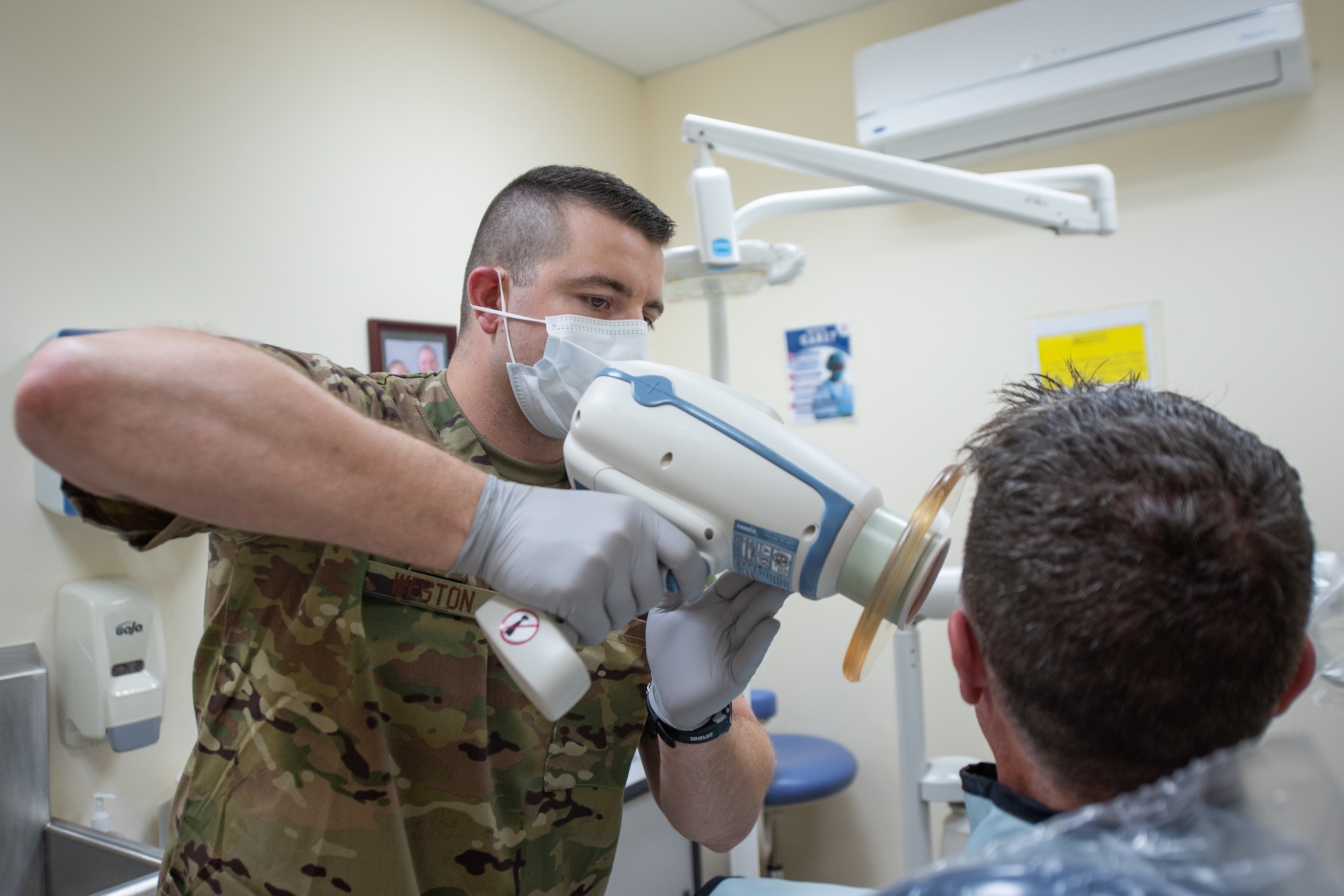U.S. Air Force Staff Sgt. Garrett Weston, 380th Expeditionary Medical Group dental element noncommissioned officer-in-charge, X-rays a patient’s teeth at Al Dhafra Air Base, United Arab Emirates, April 23, 2019. Garrett is deployed with his brother U.S. Air Force Staff Sgt. Cameron Weston, 380th Expeditionary Aircraft Maintenance Squadron F-35 Lightning II Egress technician. (U.S. Air Force photo by Staff Sgt. Chris Thornbury)
