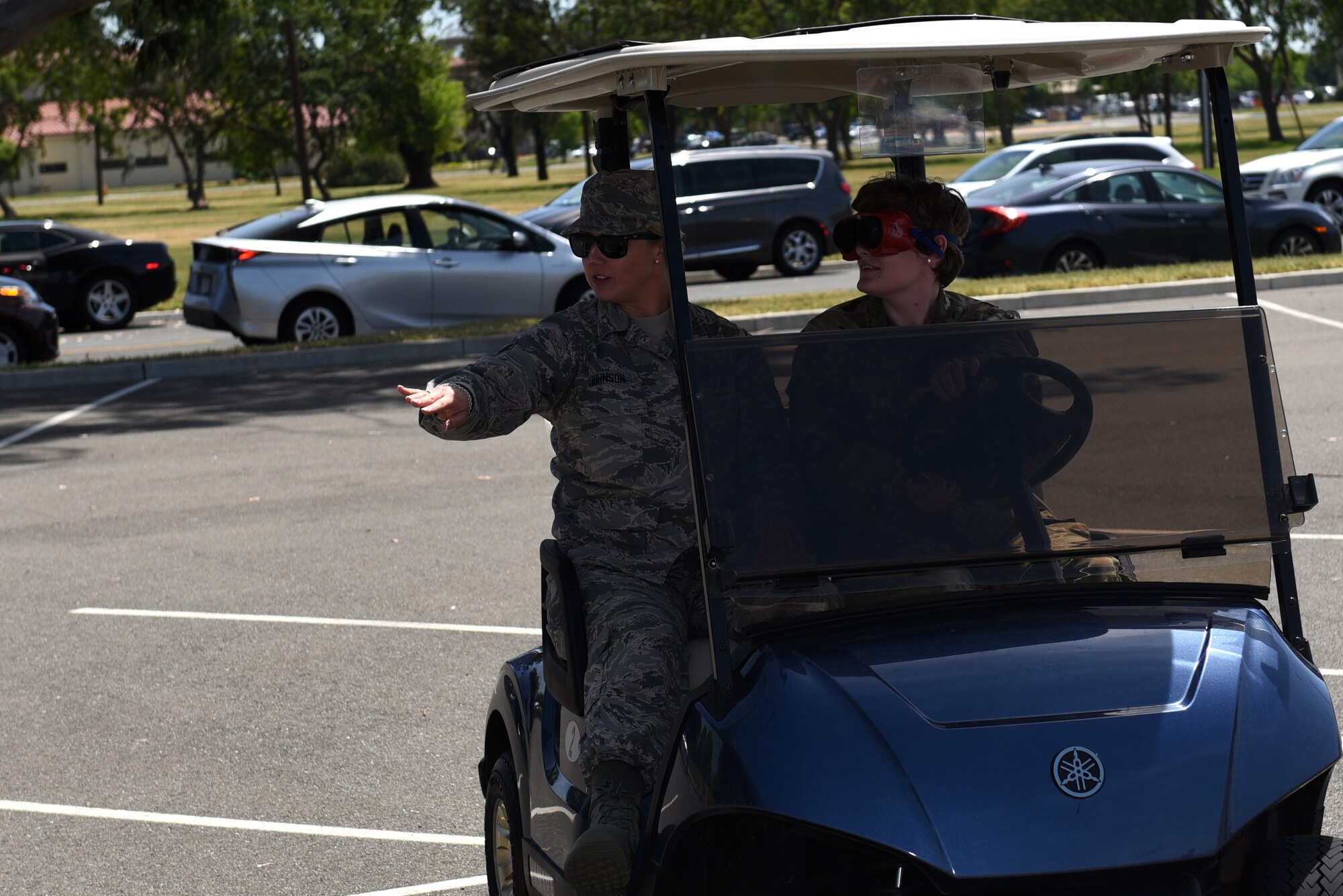 U.S. Air Force Senior Airman Meranda Macay, right, 60th Medical Operations Squadron front desk clerk, drives a golf cart with goggles that simulate the impairment of drinking while driving April 26, 2019, at Travis Air Force Base, California. The Air Force Sexual Assault Prevention and Response Office’s mission is to educate, advocate and collaborate to respond to and stop sexual assault and its harmful effects on the Air Force. (U.S. Air Force photo by Airman 1st Class Cameron Otte)