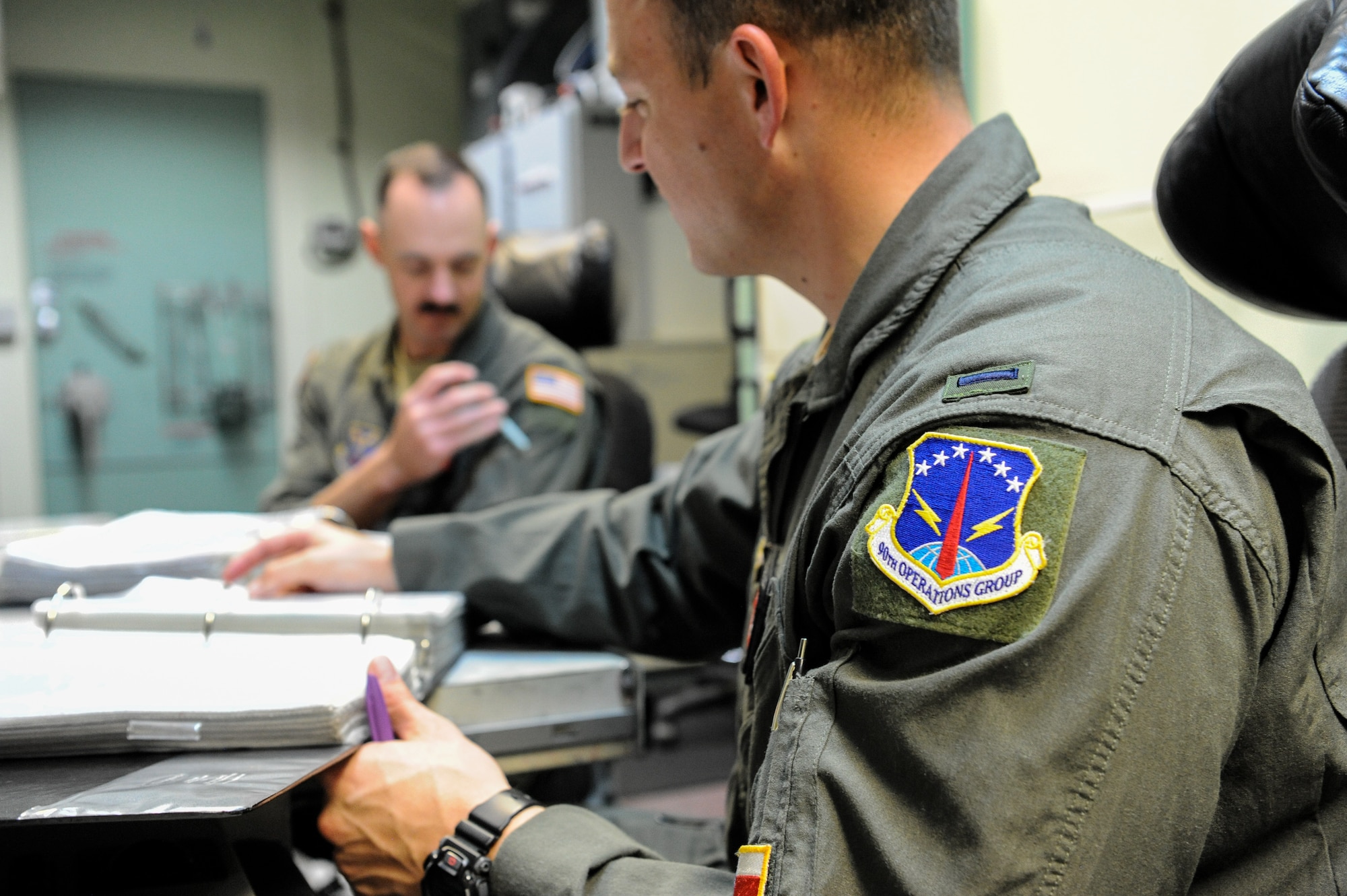1st Lt. Austin Van Hoesen, 320th Missile Squadron assistant flight commander, reviews his checklist steps with 1st Lt. Jedediah Simpson, 320 MS missileer, on F.E. Warren Air Force Base, Wyoming, April 25, 2019. The Air Force Association awarded Van Hoesen and Simpson the 2019 Gen. Thomas S. Power Outstanding Missile Crew Award. (U.S. Air Force photo by Joseph Coslett)