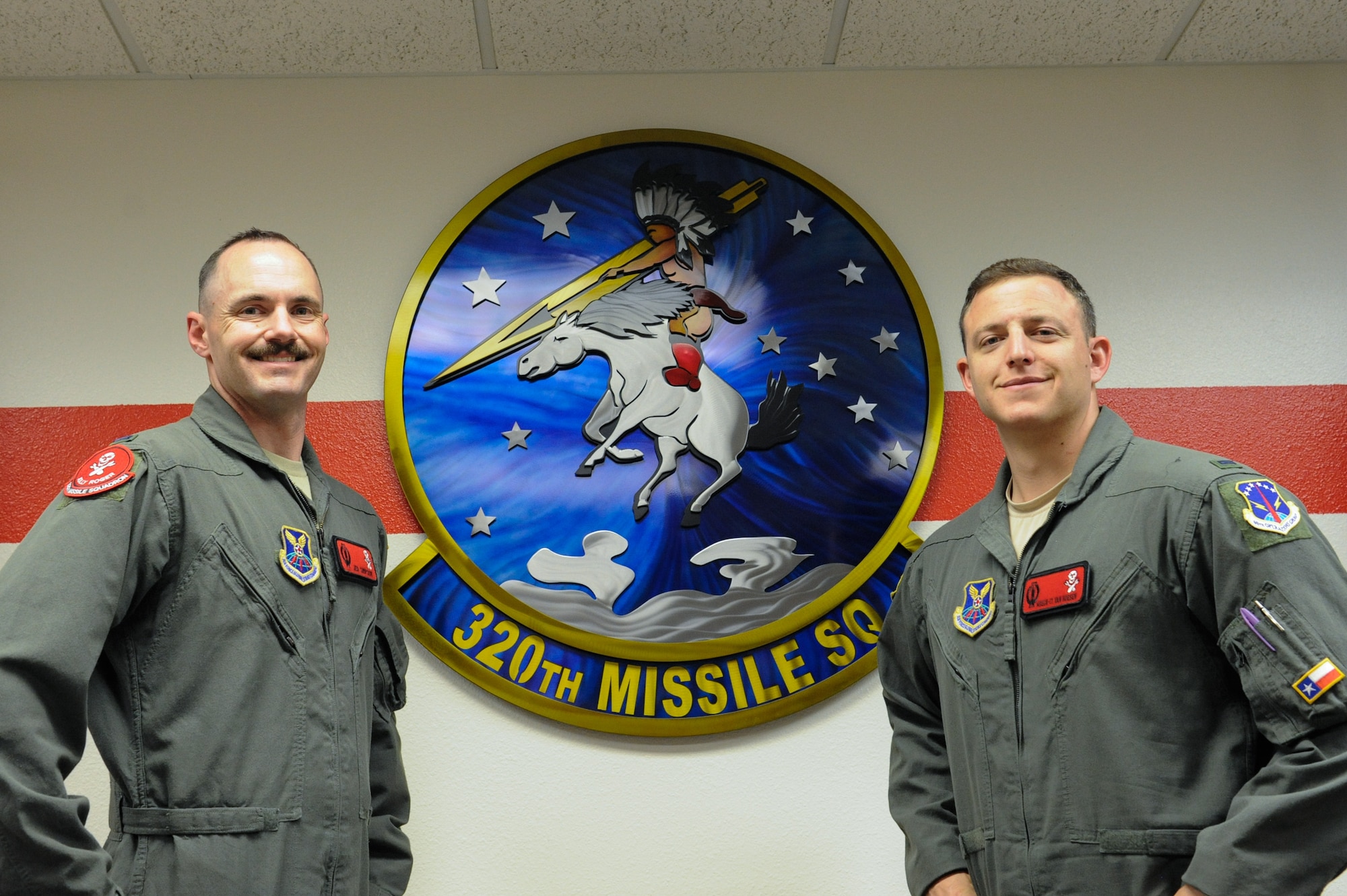 1st Lt. Austin Van Hoesen, 320th Missile Squadron assitant flight commander, and 1st Lt. Jedediah Simpson, 320 MS missilieer, pose infront of the 320 MS heritage emblem on F.E. Warren Air Force Base, Wyoming, April 25, 2019. The Air Force Association awarded Van Hoesen and Simpson the 2019 Gen. Thomas S. Power Outstanding Missile Crew Award. (U.S. Air Force photo by Joseph Coslett)