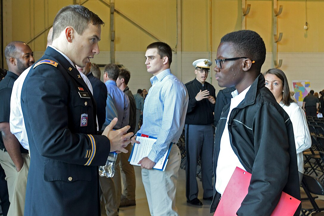 A United States Military Academy representative talks with a high school student about what it is like to attend a military academy at Dobbins Air Reserve Base, Ga. on April 27, 2019. Dobbins hosted the 20th annual Academy Day, where representatives from all the military service academies come to talk with potential attendees, and students come to meet congressional representatives (U.S. Air Force photo by Tech. Sgt.  Miles Wilson).