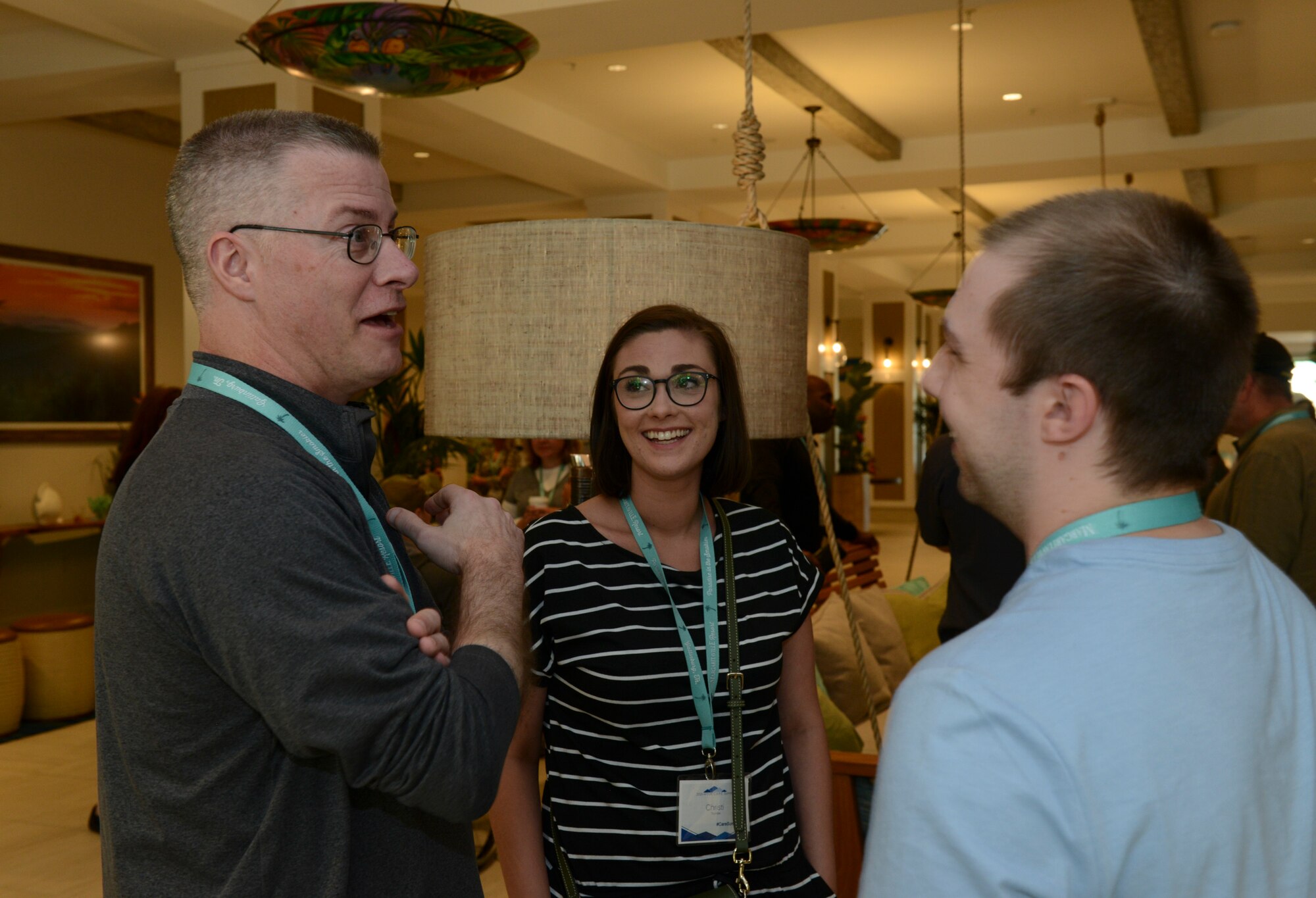 Three people talking in a resort lobby.
