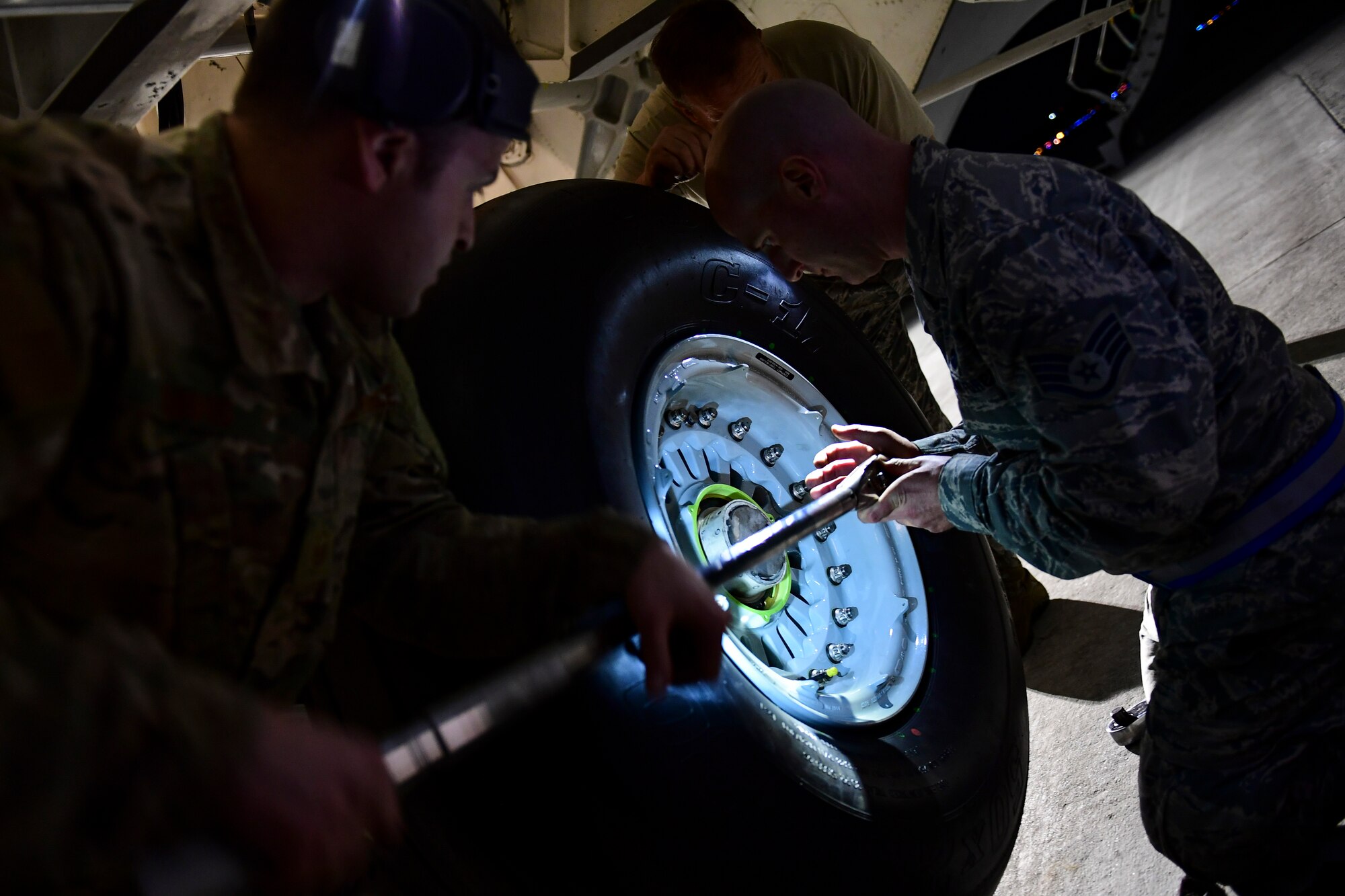Crewchiefs assigned to the 911th Aircraft Maintenance Squadron tighten a tire on a C-17 Globemaster III during a thru-flight inspection at the Pittsburgh International Airport Air Reserve Station, Pennsylvania, April 16, 2019.