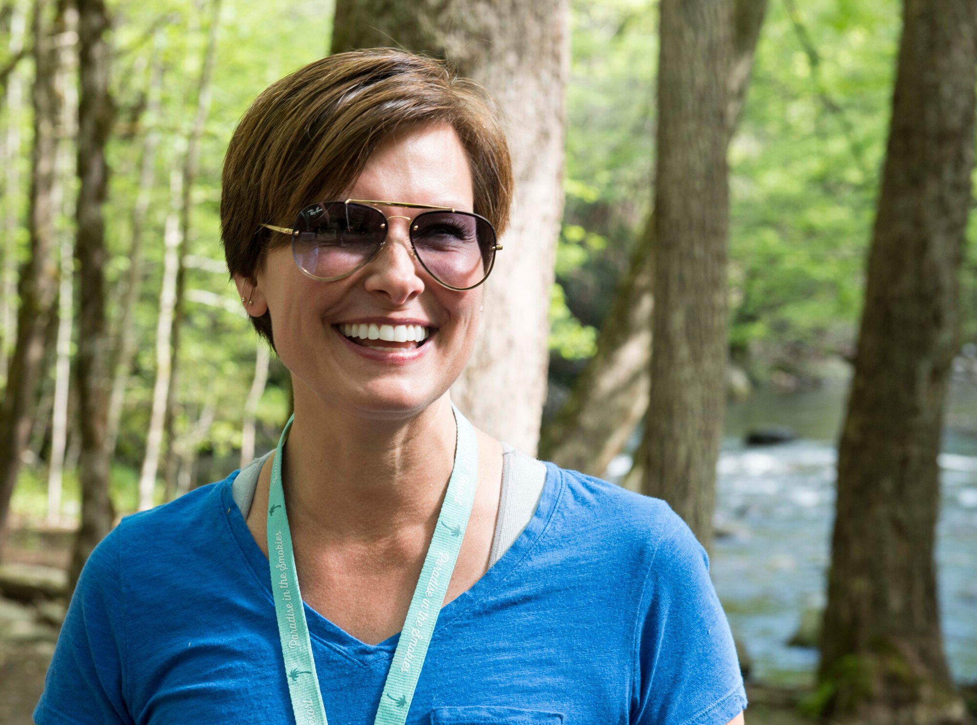 One person smiling during a hike with a river in the background.