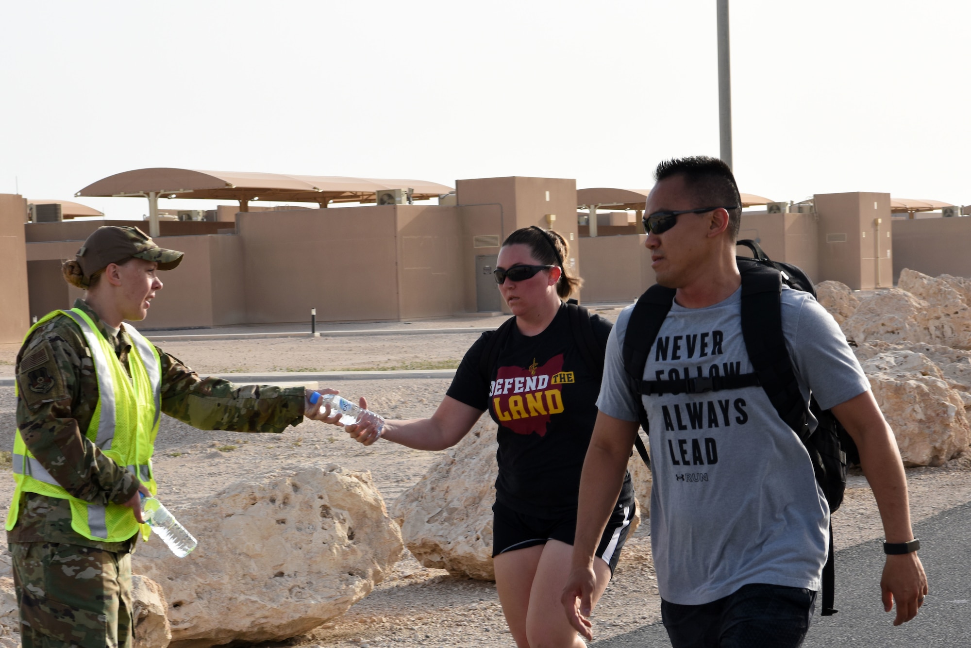 Tech. Sgt. Holly Miller, volunteer and 379th Expeditionary Operations Support Squadron crew chief passes out water during the ruck march for sexual assault and prevention month on April 26, 2019 at Al Udeid Air Base, Qatar. (U.S. Air Force photo by Staff Sgt. Ashley L. Gardner)