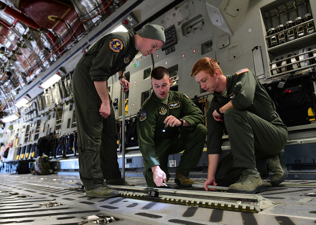 Tech. Sgt. Paul Maginnis and Staff Sgt. Carl Kocon, loadmasters with the 758th Airlift Squadron, instruct Senior Airman Steve Strobel, loadmaster with the 758th AS, standard job procedures at the Pittsburgh International Airport Air Reserve Station, Pennsylvania, April 11, 2019. Strobel came back from loadmaster technical school in January and was completing his on the job training.(U.S. Air Force Photo by Senior Airman Grace Thomson)