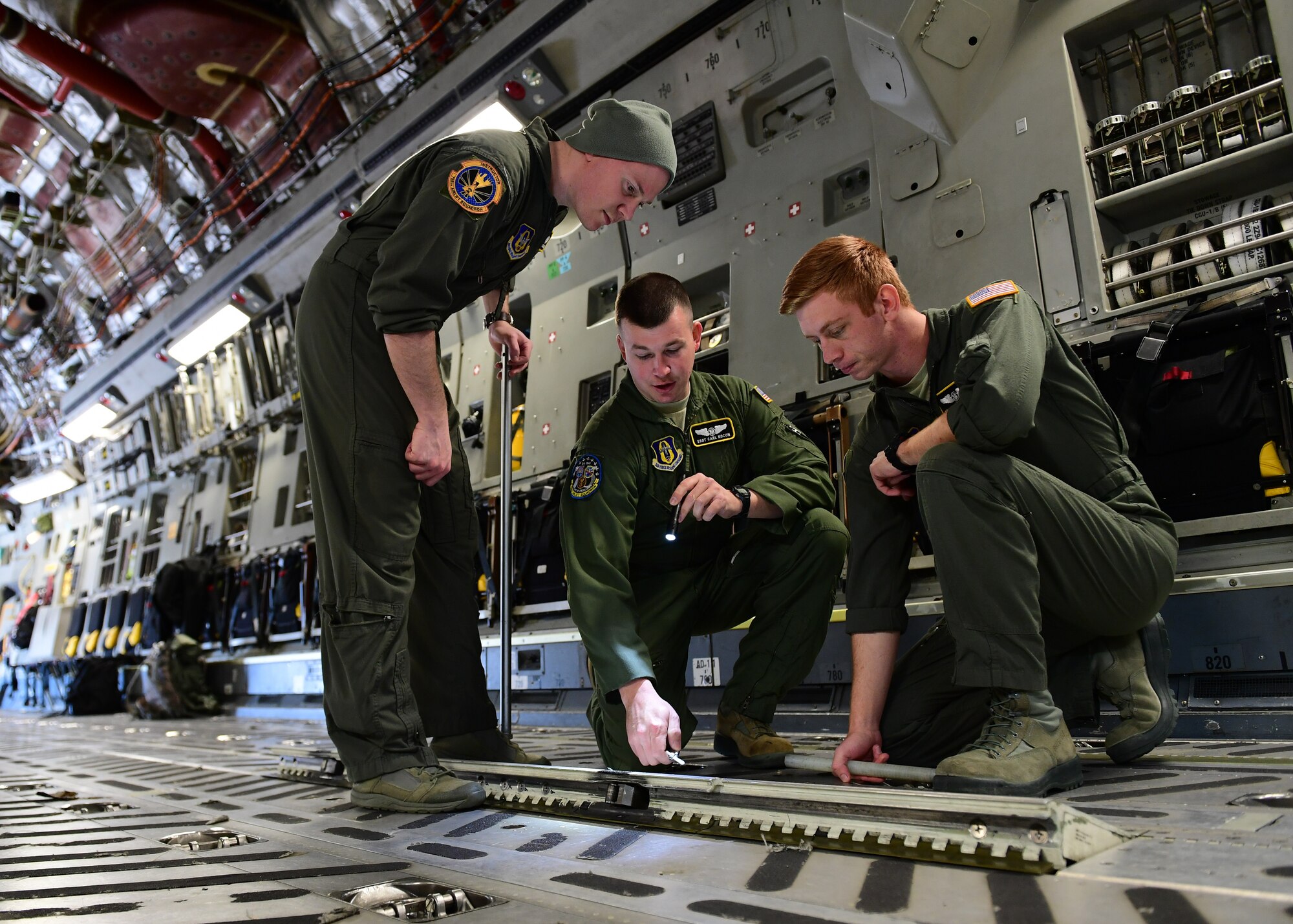 Tech. Sgt. Paul Maginnis and Staff Sgt. Carl Kocon, loadmasters with the 758th Airlift Squadron, instruct Senior Airman Steve Strobel, loadmaster with the 758th AS, standard job procedures at the Pittsburgh International Airport Air Reserve Station, Pennsylvania, April 11, 2019. Strobel came back from loadmaster technical school in January and was completing his on the job training.(U.S. Air Force Photo by Senior Airman Grace Thomson)