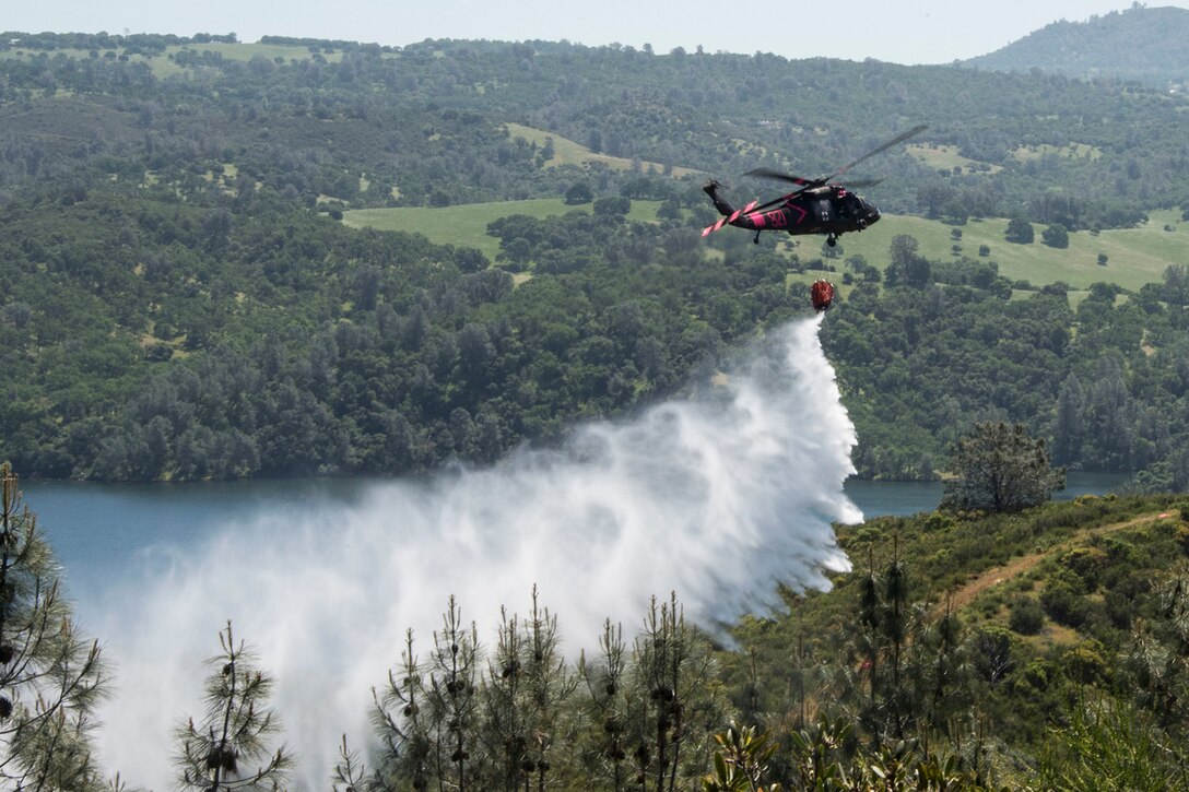 A helicopter conducts water drop operations.